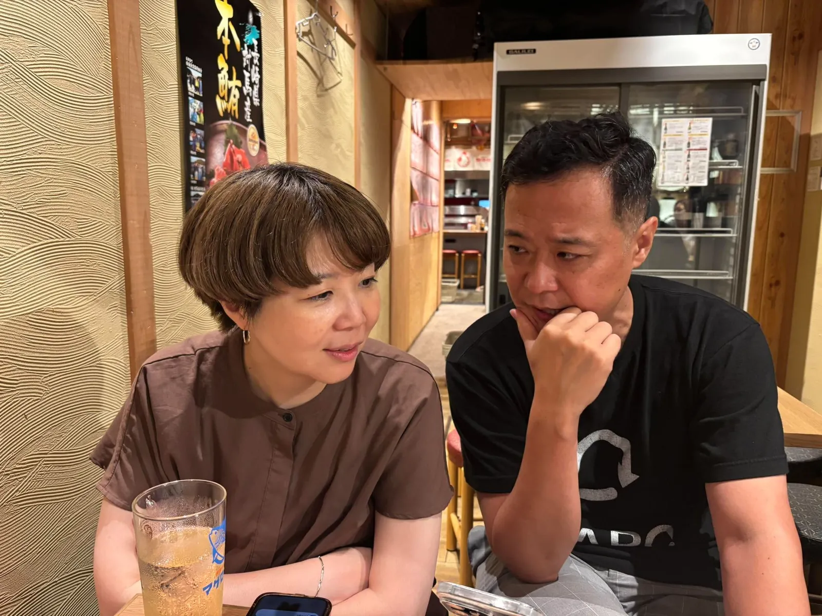 飲食店の席で向かい合って話す2人
