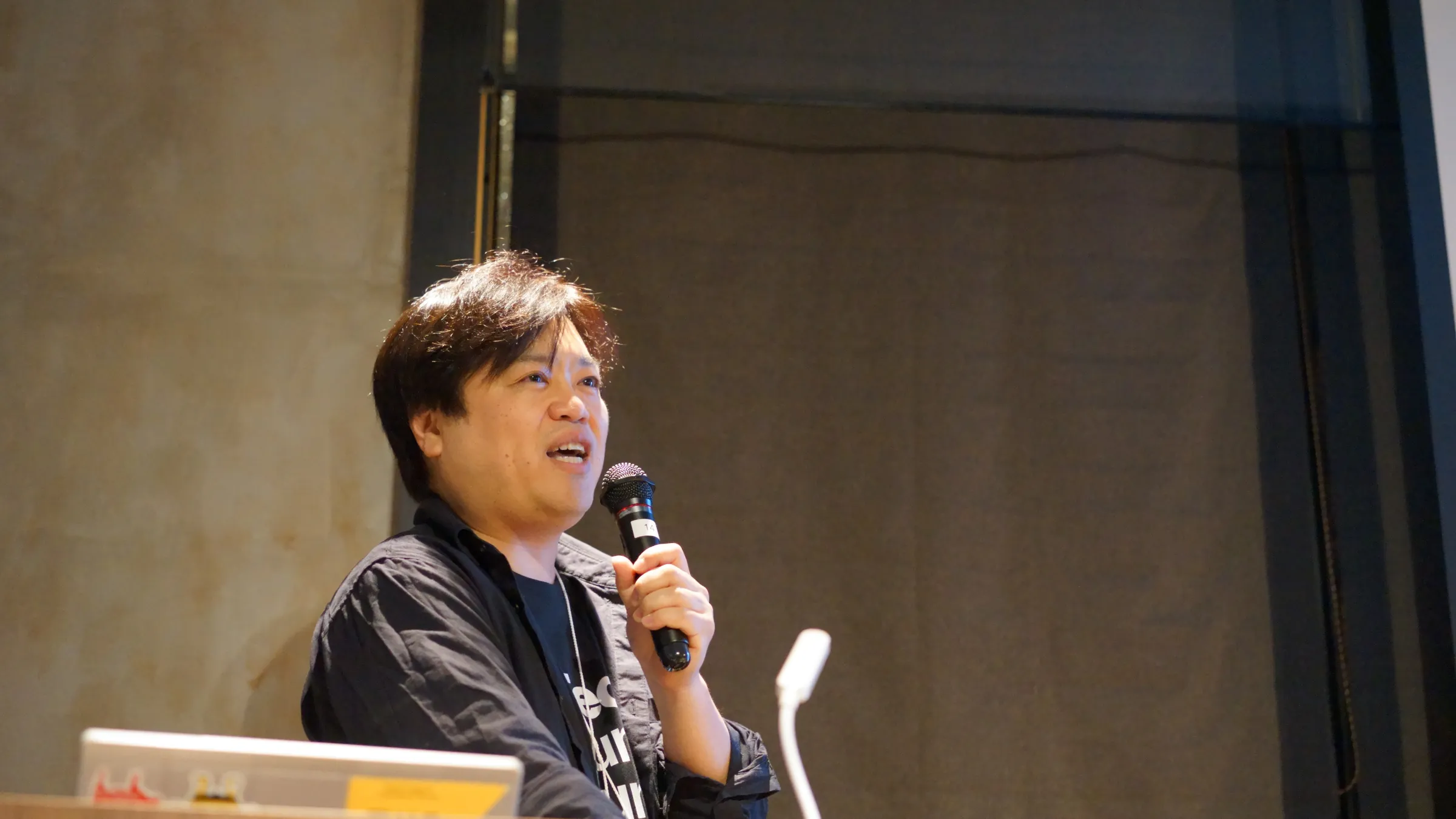 2025年3月の総会・懇親会で、マイクを持って話す登壇者