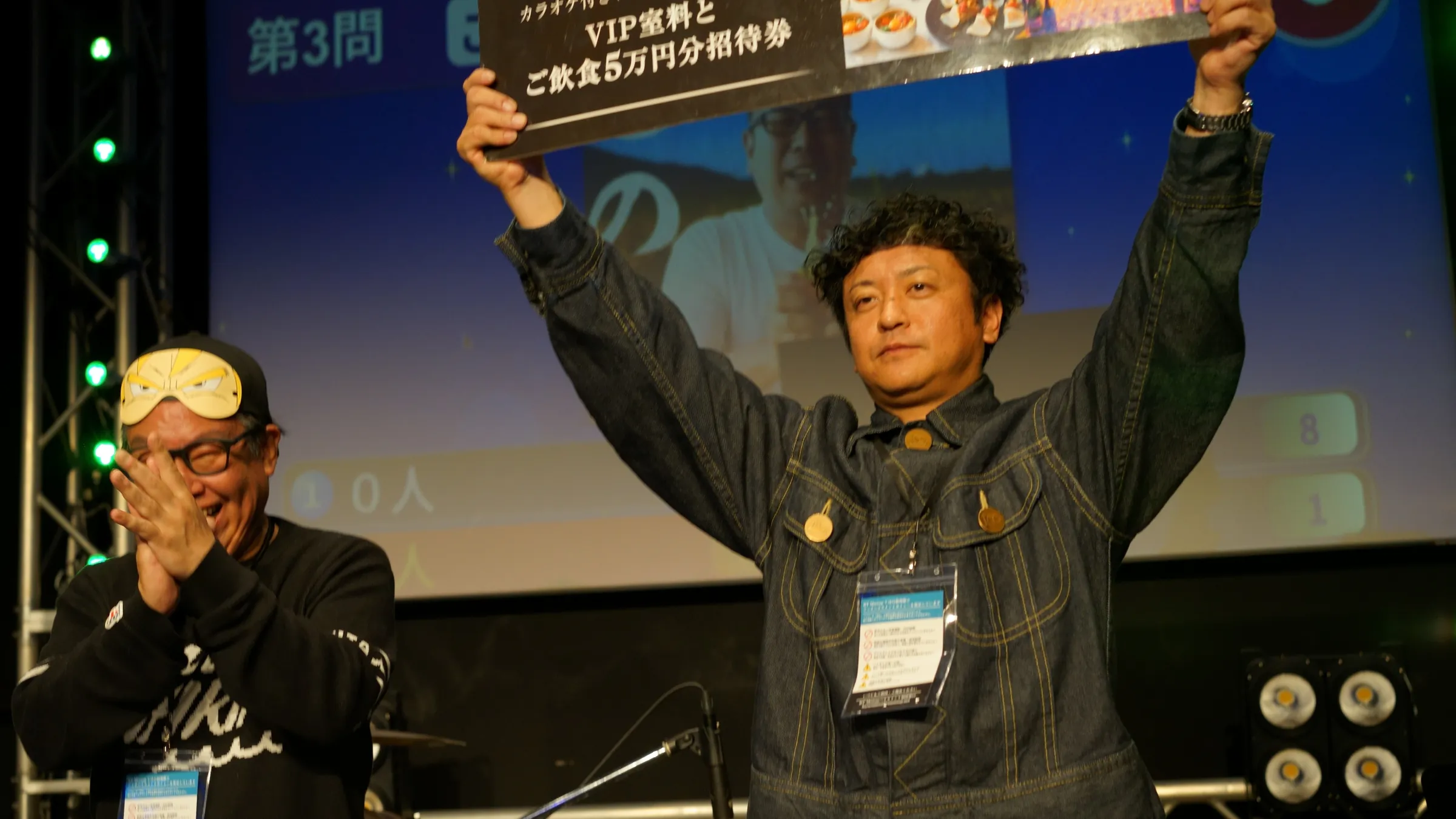 2026年2月20日、銀座で開いた年次総会で、賞品のボードを掲げる参加者